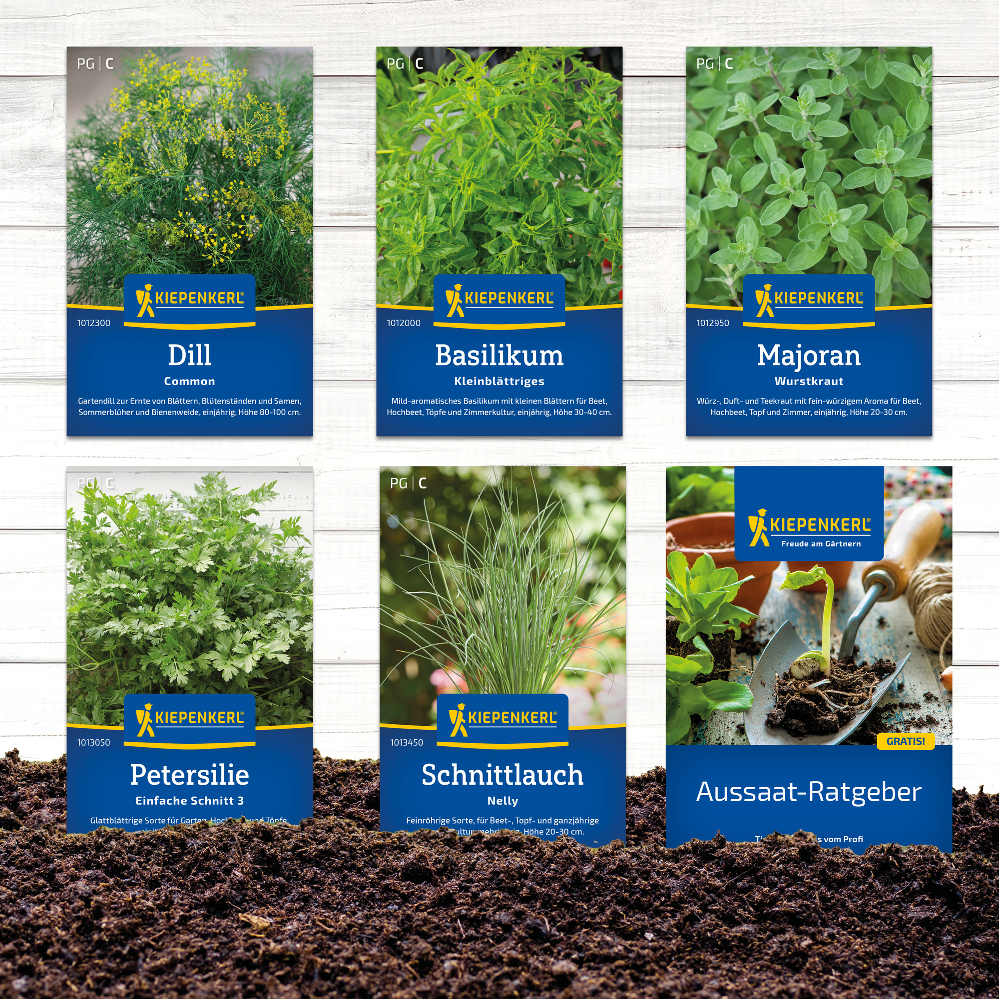 Saatgutpakete für Dill, Basilikum, Majoran, Petersilie, Schnittlauch und ein Aussaat-Ratgeber liegen im Boden, im Hintergrund sind weitere Samenpackungen sichtbar.