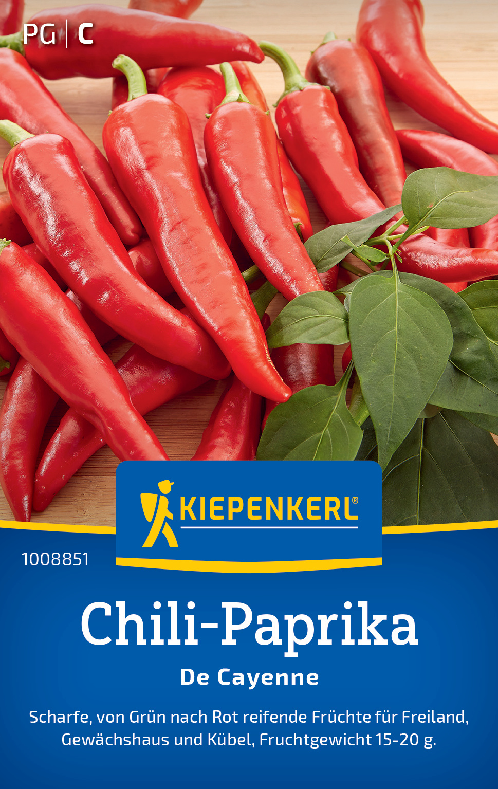 Rote Chili-Paprika mit grünen Blättern auf Holzuntergrund, Verpackung mit Blauer Beschriftung.